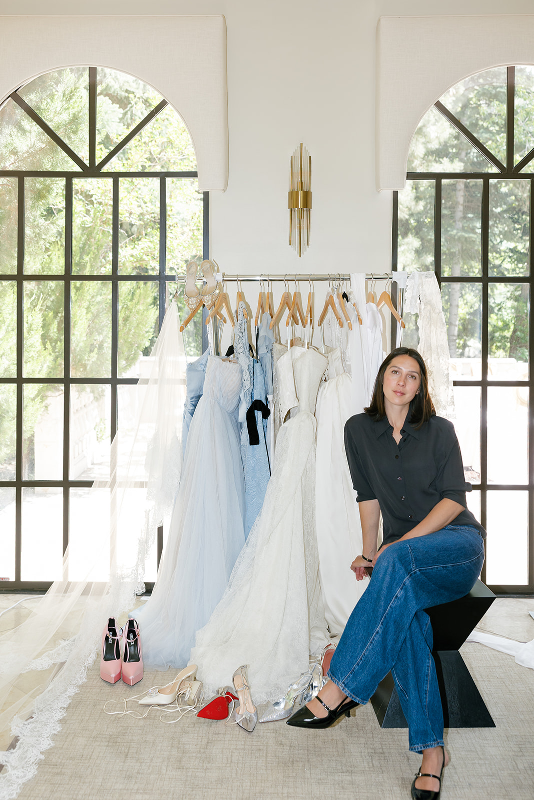Sam Ruiz, bridal fashion stylist, with bridal wardrobe rack